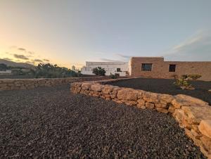 a stone retaining wall in front of a building at Los Nopales Fuerteventura in Antigua