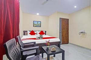 a hotel room with a bed and a table and a chair at Super Hotel O Qualia Pride Financial District in Hyderabad
