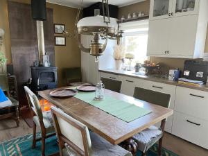 una cucina con tavolo in legno, sedie e piano cottura di 5 person holiday home in ADELSÖ ad Adelsö Altre 18 foto