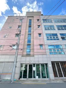 a pink building with a lot of windows at Aurora Stay in Pongsan-dong