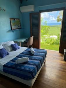 Un dormitorio con una cama y una mesa y una ventana. en Hélios Zion, en Capesterre-Belle-Eau