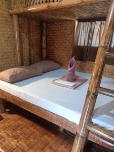 a bunk bed with a hat on top of it at Villa Skanderbeg Guest House Talaudyong Beach in Bacungan