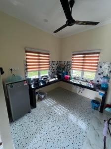 a kitchen with a desk and two windows in a room at Adam Hawa Homestay Bachok in Bachok