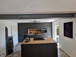 a kitchen with black cabinets and a wooden counter top at Chalet Bambi in Blaibach