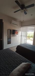 een slaapkamer met een bed en een plafondventilator bij El paraíso del descanso in El Jobo