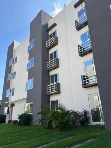 een groot wit gebouw met balkons aan de zijkant bij El paraíso del descanso in El Jobo