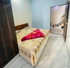 een slaapkamer met een bed met een rood kussen erop bij Preet Guest House in Kedārnāth