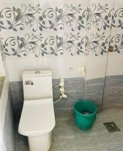 een badkamer met een toilet en een emmer bij Preet Guest House in Kedārnāth