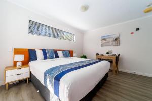 a bedroom with a large bed and a desk at Spacious Mantra Hotel Room in Urangan