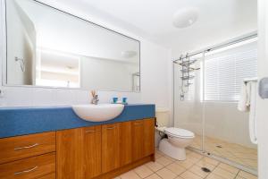 a bathroom with a sink and a toilet at Spacious Mantra Hotel Room in Urangan +4 photos