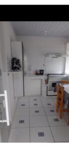 a small kitchen with white cabinets and a table at Casa da Lu in Aparecida +12 photos
