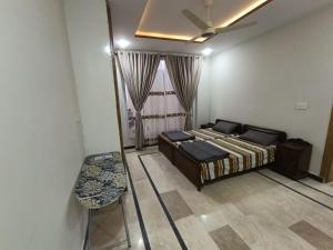 a bedroom with a bed and a chair and a mirror at RMT Residencia in Peshawar