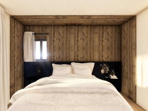 a bedroom with a large bed with a wooden wall at Chalet moderne avec sauna et jacuzzi à Courchevel pour 8 adultes et 5 enfants - FR-1-562-89 in Courchevel