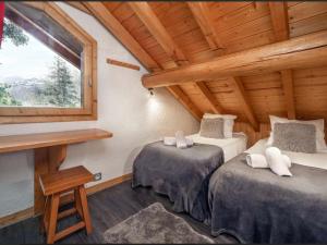 a bedroom with two beds in a log cabin at Chalet à Méribel avec service de conciergerie et animaux admis - FR-1-613-143 in Méribel