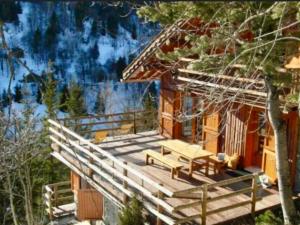 a wooden deck with a bench and a house at Chalet à Méribel avec service de conciergerie et animaux admis - FR-1-613-143 in Méribel