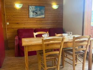 a wooden table with chairs and wine glasses on it at Appartement 2 chambres aux pieds des pistes, parking gratuit - FR-1-807-125 in Saint-François-Longchamp