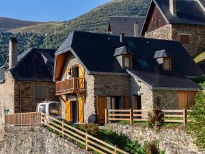 une grande maison en pierre avec un toit noir dans l'établissement Chalet pyrénéen chalet à Soulan pour 12 pers., WiFi, proche ski - FR-1-296-528, à Soulan