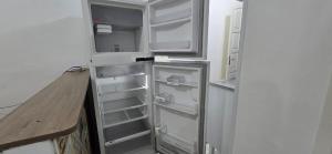 イタニャエンにあるCasa térrea com 2 quartos em Itanhaemのキッチンにあるドアが開いたままの空の冷蔵庫