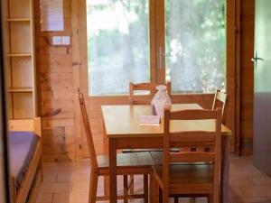 a dining room with a table and chairs and a window at Appartement cosy avec terrasse à Sauveterre-de-Rouergue - API-1-52-755 in Sauveterre-de-Rouergue