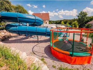 ein Spielplatz mit Rutsche in einem Park in der Unterkunft Appartement confortable avec cuisine équipée - API-1-52-759 in Barbey-Séroux
