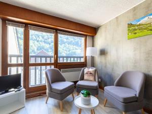 ein Wohnzimmer mit zwei Stühlen und einem Fernseher in der Unterkunft T3 lumineux pour 6 personnes au cœur de Saint-Lary - FR-1-296-526 in Saint-Lary-Soulan