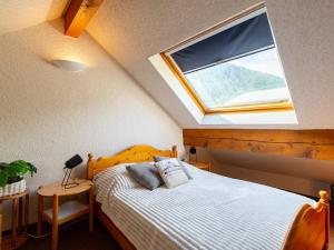 ein Schlafzimmer mit einem Bett mit einem großen Fenster in der Unterkunft T3 lumineux pour 6 personnes au cœur de Saint-Lary - FR-1-296-526 in Saint-Lary-Soulan