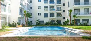 a swimming pool in front of a building at Affordable Luxury Apartment in Nouaseur