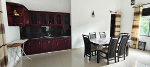 a kitchen with a table and chairs and a sink at Roamers Ark Galle in Galle