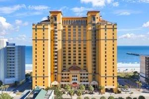 a large yellow building with the ocean in the background at Anderson Ocean Club #1611 in Myrtle Beach