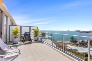 a balcony with chairs and a view of the ocean at Luxe at Oshen Yeppoon in Yeppoon