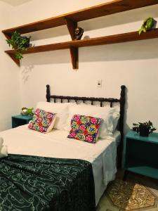 a bedroom with a bed with two pillows on it at Villa Pachamama Hospedaria - Praia do Rosa in Praia do Rosa