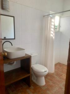une salle de bain avec des toilettes blanches et un lavabo dans l'établissement Casa del Alma, à Puerto Escondido