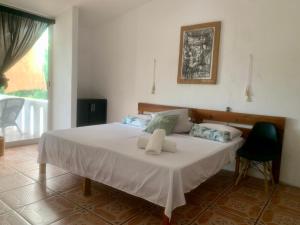 une chambre avec un grand lit avec des draps blancs dans l'établissement Casa del Alma, à Puerto Escondido