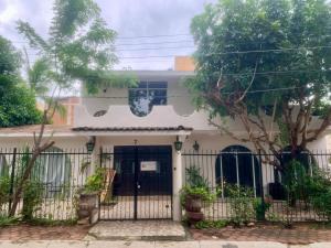 a white house with a gate and trees at Casa del Alma in Puerto Escondido