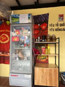 a refrigerator with its door open next to a shelf at Fish Farm Homestay in Yên Bái