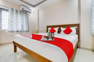 une chambre avec un grand lit avec des oreillers rouges dans l'établissement Hotel O Mr Guestline, à Bangalore