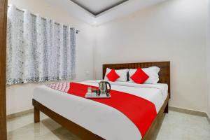 a bedroom with a large bed with red and white pillows at Hotel O Mr Guestline in Bengaluru +39 photos