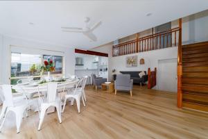 a dining room with a white table and white chairs at Scarness Spacious Home with Pool in Scarness