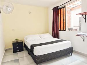a bedroom with a bed and a window at Casa Eclat in Medellín