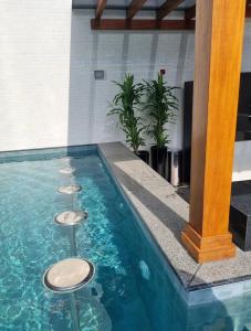 una piscina con tres taburetes en el agua en Apartamento vista Mar Piscina na Cobertura, en Itapema