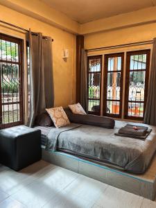a bedroom with a large bed with windows at Baan Mali Koh Kood in Ban Hin Dam