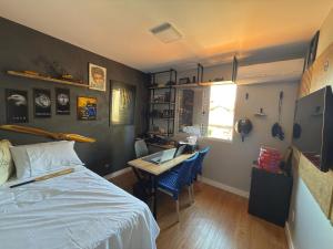 Un dormitorio con una cama y un escritorio con una computadora. en Casa de condominio mobiliada Prox. MOTOGP, en Goiânia