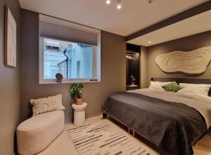 Un dormitorio con una cama y una ventana y una silla. en Brand New & High-End 3 Bedrooms 2 Bathrooms Central Apartment, en Bergen