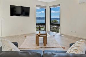 サンディ・ベイにあるThe View Luxury home 6 bed 4 bathのソファとテーブルのあるリビングルーム