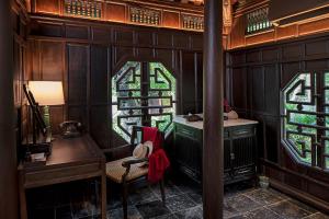a room with a desk and stained glass windows at Ancient Huế Garden Houses in Hue