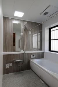 een grote badkamer met een bad en een douche bij Guest House景 in Kumamoto +27 foto's