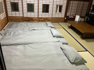 een groot bed in een kamer met een tafel bij Guest House景 in Kumamoto
