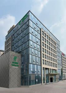 Un edificio alto de cristal con un cartel. en Holiday Inn Jinan Thousand Buddha Mountain by IHG, en Jinan