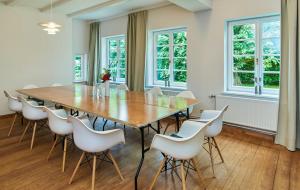 a dining room with a large wooden table and white chairs at Artist's Studio House In Aukrug Nature Park in Meezen +32 photos