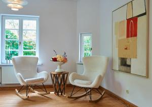 two chairs in a room with a vase on a table at Artist's Studio House In Aukrug Nature Park in Meezen